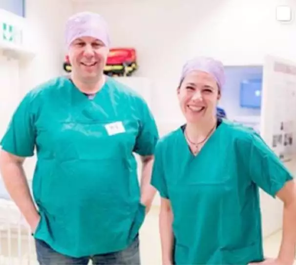 Zwei Pflegefachkräfte von Hire-a-Doctor im grünen Kittel am Einsatzort, lächeln während ihrer Arbeit.